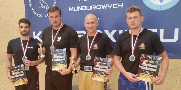 Płoccy kickbokserzy w mundurach na podium